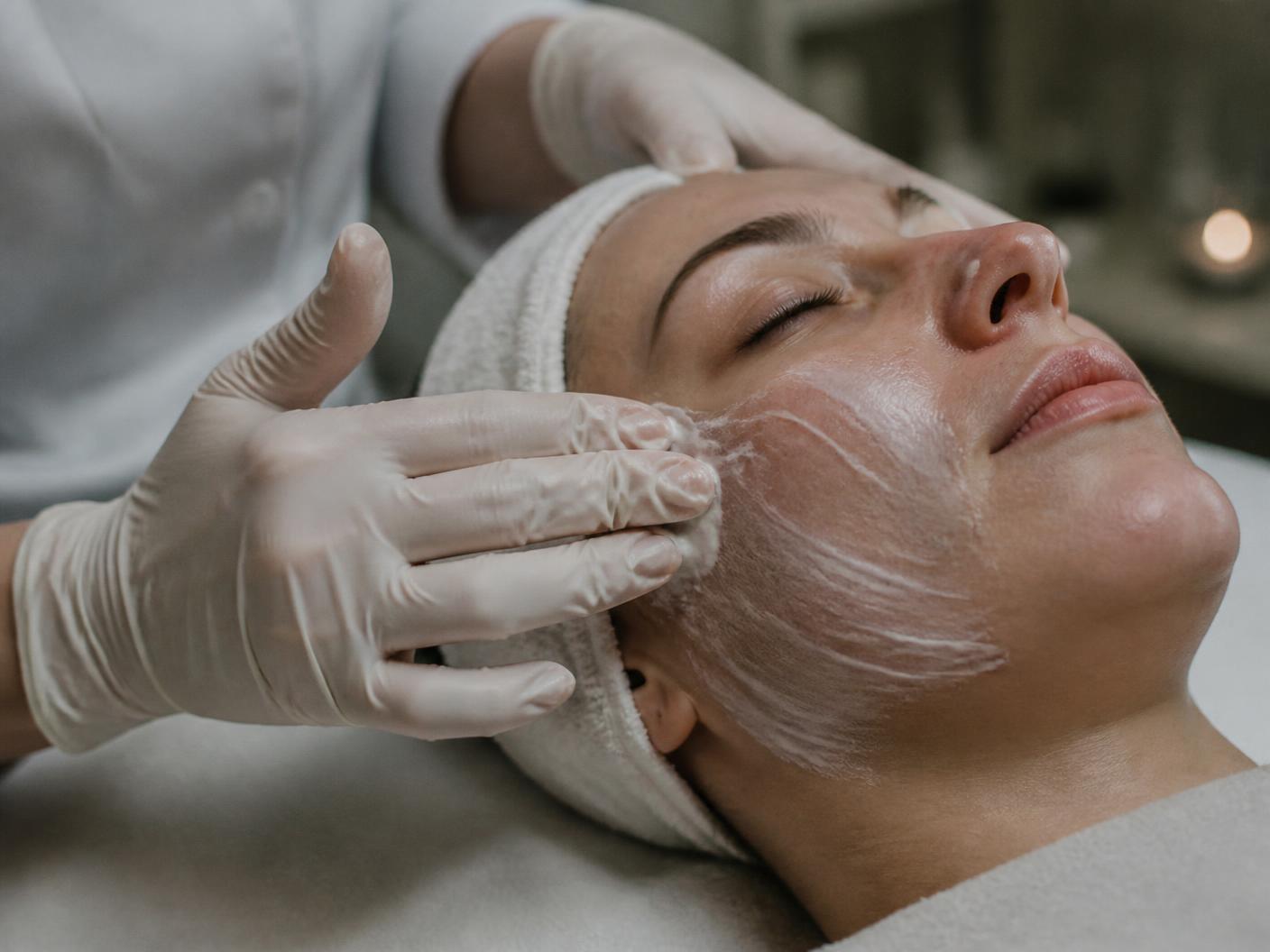 Trattamento professionale del viso in cabina, applicazione di prodotto con pennello